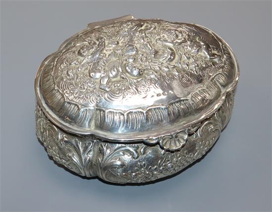 An early 20th century continental repousse silver oval trinket box, decorated with cherubs, import marks for London, 1928, 15.5cm.